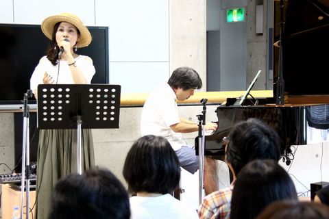 ステージで歌うYUUMIさんとピアノを演奏する高野さん