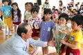 カーネーションの花束を横須賀幼稚園の園児にプレゼントする花の生産者の大場猛雄さん