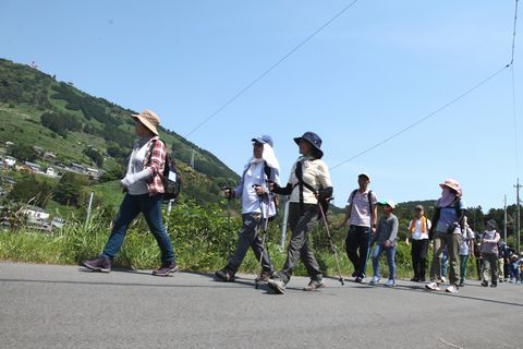 シンボルの茶文字を眺めながら粟ヶ岳山頂を目指して歩く参加者ら