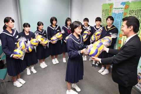 若杉組から検定球の寄贈を受けるセーラー服姿の女子中学生9人