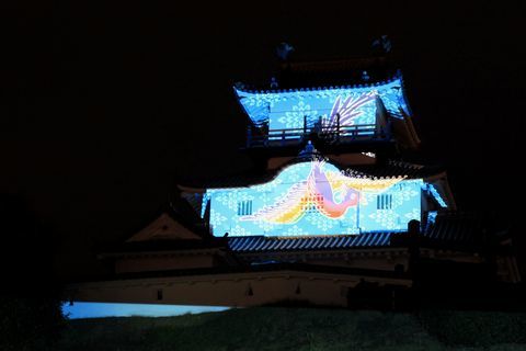 暗闇の中、青い光の映像が映し出された掛川城天守閣