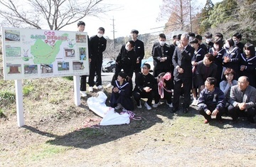 完成したばかりの案内看板を眺める生徒と東山口地区の役員の人達