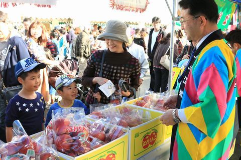 姉妹都市奥州市の特産品を買い求める来場者とカラフルなハッピを着て対応をするスタッフ