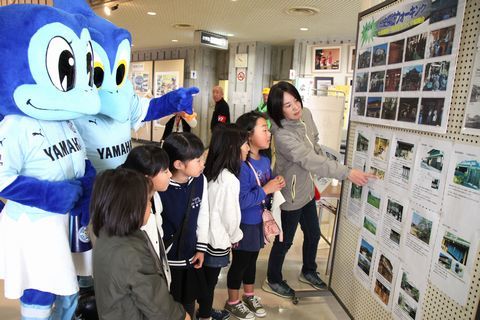 活動紹介をする役員の女性と話を聞く子供たち