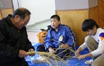 和田岡小学校児童がアドバイスを受けながらしめ飾りを作る様子