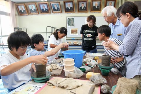 真剣な眼差しで円筒状に成形している子どもたち