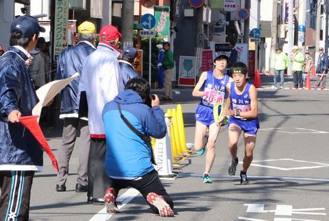 第10中継所で11区の松浦さん(右)の力走をカメラに収める観客ら