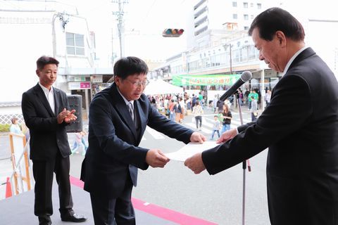 「やぶきた」と「つゆひかり」の2冠を達成した御林茶業組合の杉本代表理事組合長(中央)が松井会長（右）から賞状を受け取るようす