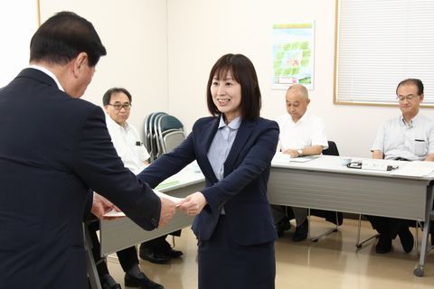 中小企業振興会議で松井市長が委嘱書を渡し山本さんが笑顔で受け取る様子