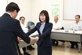 中小企業振興会議で松井市長が委嘱書を渡し山本さんが笑顔で受け取る様子