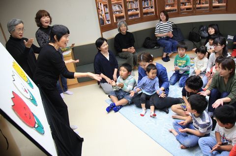 図書館活動グループのポラリスメンバーと童謡さいた さいたを歌う親子