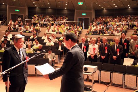 松井市長から自治区役員功労表彰を受ける伊藤達さんとその奥に他の表彰者