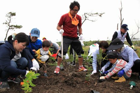 NPO法人時ノ寿の森クラブの指導のもと植樹を行う親子連れ