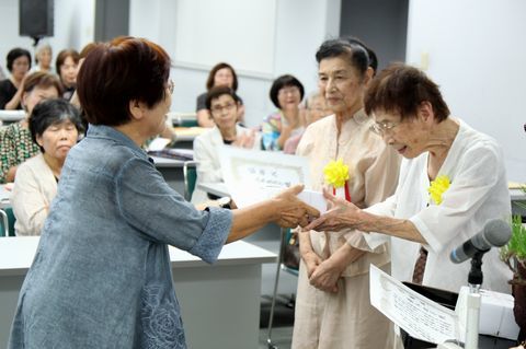 桑原会長から山本さんと鈴木さんが感謝状を受け取る様子