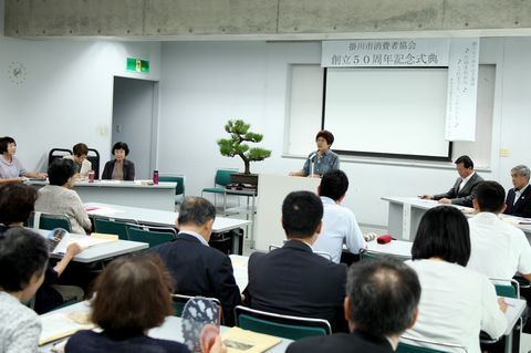 式典で桑原会長があいさつしている様子