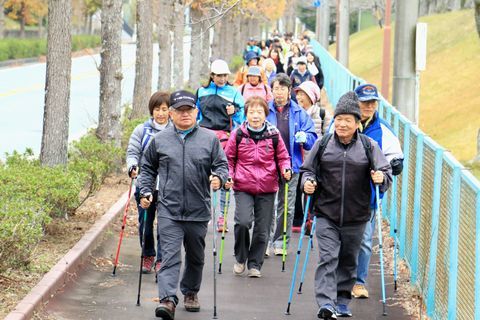 両手にポールを持ち、会話をしながら軽快に歩くお年寄りのたち