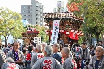 天皇陛下御即位奉祝行事で華やかな屋台の周りに法被姿の人々が集まっている写真