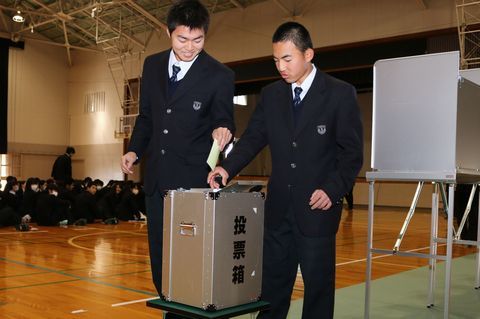 投票方法を体験する生徒たちが投票箱に票を入れる様子