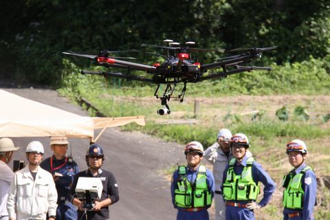 上空からの撮影に向かうドローンと操作する人たち