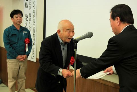松井市長から最優秀賞を表彰される男性と表彰を待つ男性の写真