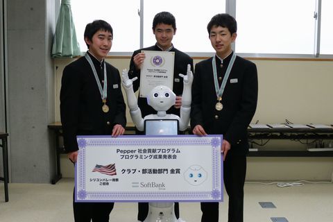 金賞を受賞し、人型ロボットPepper(ペッパー)を囲み笑顔でポーズを決める山崎さん戸塚さん松下さんの写真