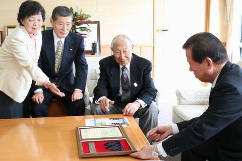 南郷地区まちづくり協議会の役員ら3人が松井市長に受賞を報告している様子