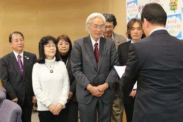 かけがわ乳幼児教育未来学会（鷲山恭彦会長）と委員会メンバーが掛川市役所で松井市長に提言書を手渡す様子。