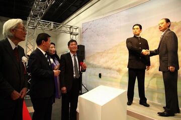 ２体のろう人形を見ている王起宝館長、松井市長、鷲山会長