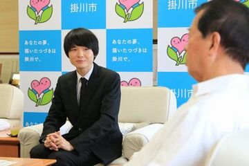 席に着き、松井市長と談笑する佐藤さんの写真