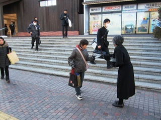 駅舎のPR小冊子を道行く人に配布する保存・活用する会のメンバー