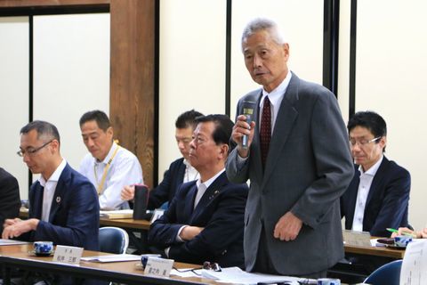 参加者の前で挨拶する会長。