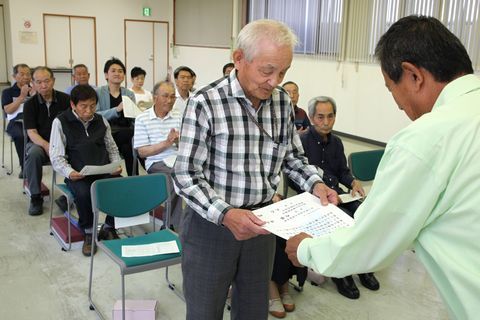 入選者が着席する前で、内藤会長から表彰状を受け取る松浦さんの写真