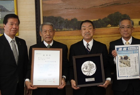 表彰状を披露する松下区長と副区長2人と松井市長
