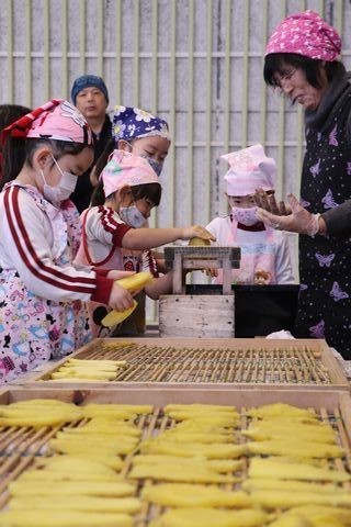 ペンペンを使って芋切り干しづくりをする園児たち