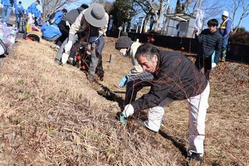 天竜浜名湖鉄道細谷駅の線路沿いにユキヤナギの苗を植える参加者ら