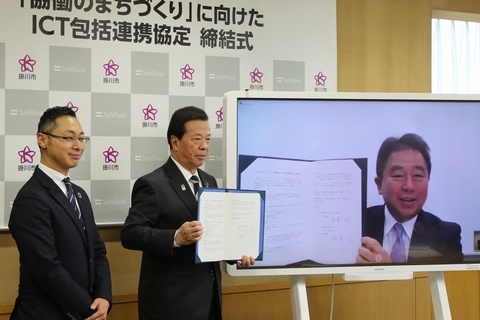 モニターに映る榛葉副社長と会場の松井市長が交わした協定書を掲げている写真