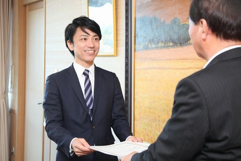 松井市長から笑顔で委嘱書を受け取るスーツ姿の森澤さん