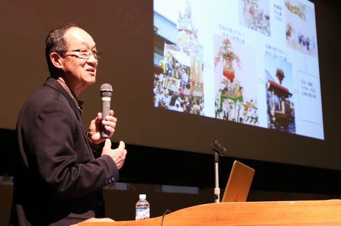 講演でスライドを見せながら大祭の歴史的価値を解説する田中さん