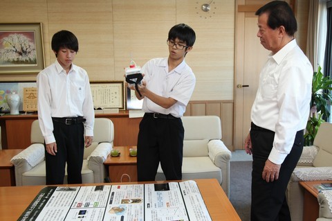空中からDNA採取する独自の装置を手に文部科学大臣賞を受賞した二人が松井市長に報告している。