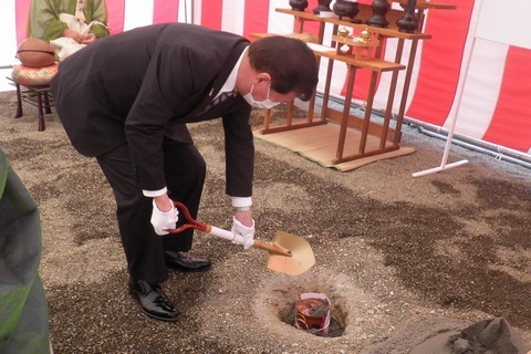 地鎮式でスコップを持ち鎮物埋納の儀を行う松井市長