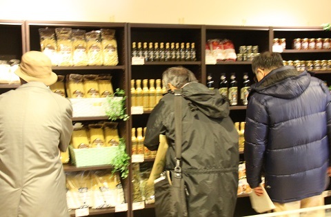 ペーザロ産のワインやチーズを購入できる1階販売所で買い物をする人たち