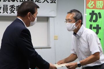 第21回静岡県市町対抗駅伝競走大会の市選手団役員委嘱式で、松井団長 (左)から委嘱書を受け取る原田監督(右)