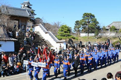 行進をする消防団員と沿道に集まった大勢の人々