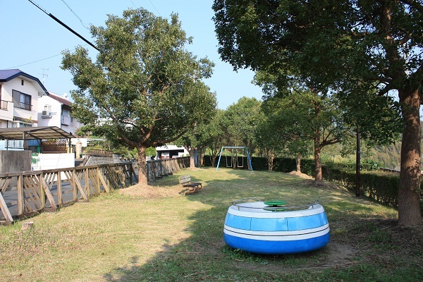 葛ヶ丘ふれあい公園 奥にブランコ等の遊具があり、芝生が敷き詰められている