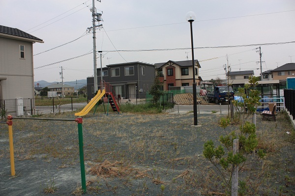 鷺田南公園の様子、広いアスファルトの土地にすべり台や鉄棒、ベンチが設置されている