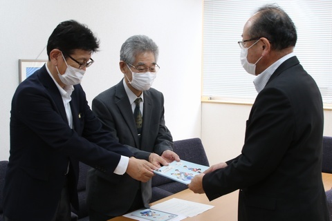 左側の石原央支部長らから冊子を受け取る佐藤教育長の画像