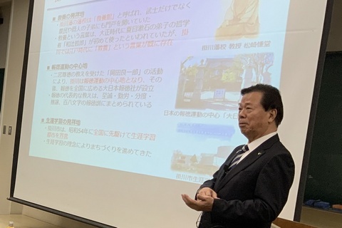 スクリーンの前で説明する松井市長