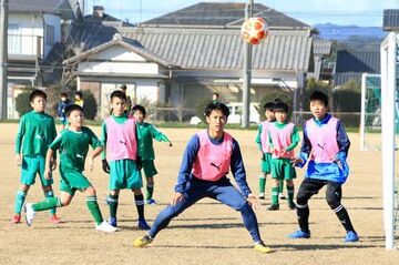 飛んでくるボールを見つめる森下選手とゲームを楽しむ子どもたち