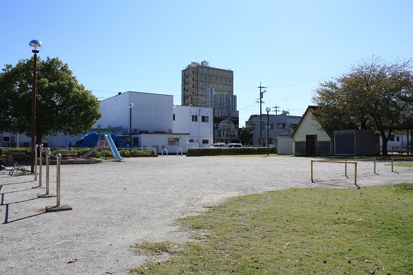 鉄棒、滑り台がある駅前公園の風景