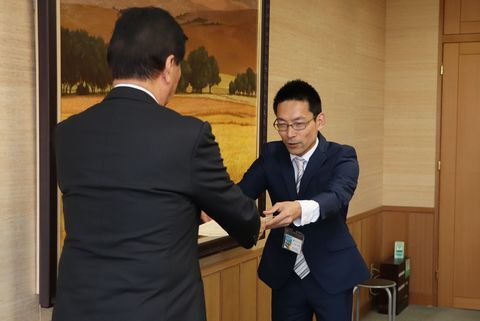 松井市長から認定書を受け取るスーツ姿のアドバイザーの吉本みかんさん